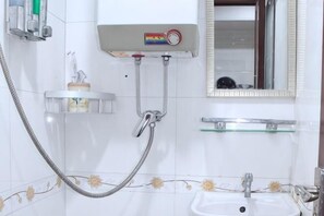 Ein Badezimmer mit Dusche, Waschbecken und Spiegel.