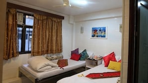 A room with two beds, a ceiling fan, a window with curtains, a nightstand, and a wall-mounted picture. - Leisure Hostel (Hong Kong)