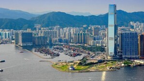 A high-rise building with a modern glass facade, surrounded by a dense urban area with numerous other high-rise buildings. - Leisure Hostel (Hong Kong)