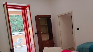 A bedroom with a bed, a wardrobe, and an open door leading to an outdoor area. - Casalabate Apartment by CDA Accommodation (Squinzano)