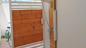 A wooden gate leading to a bathroom with a shower and a water tank on the wall. - Casalabate Apartment by CDA Accommodation (Squinzano)