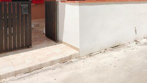 A residential building with a balcony, a gated entrance, and a red door. - Casalabate Apartment by CDA Accommodation (Squinzano)