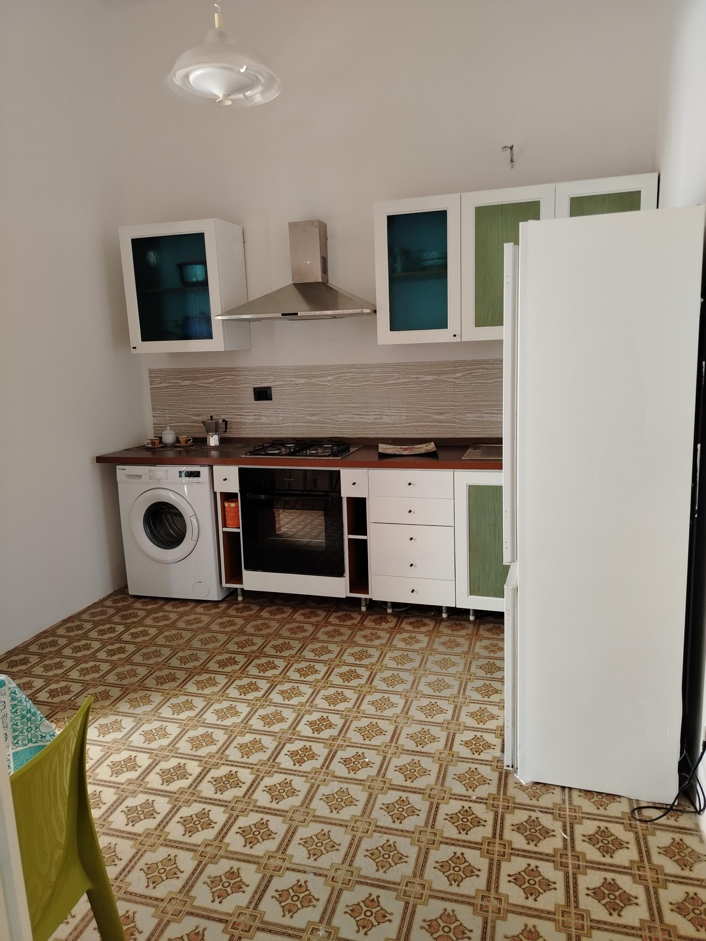 Uma cozinha compacta com máquina de lavar, forno e frigorífico.