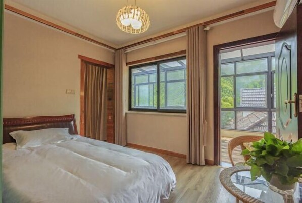 Une chambre à coucher avec un lit, une fenêtre avec des rideaux, une chaise et une plante en pot.