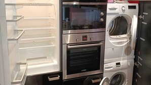A compact kitchen with a built-in refrigerator, oven, and washing machine. - Lavandou Maison de Ville Duplex ,400 Mètres des Plages. Ideal Pour les Familles (Le Lavandou)