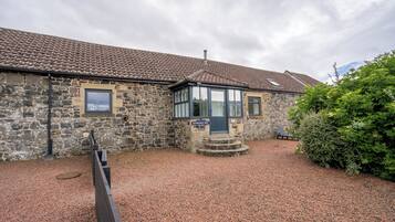 Step into Bamburgh First, a historic property with a charming entrance and inviting porch.