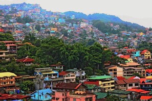 A densely populated hillside town with closely packed buildings and lush greenery. - RedDoorz Hostel @ Ritz Place Baguio (Baguio)