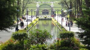 A garden with a central water feature, surrounded by trees and pathways. - RedDoorz Hostel @ Ritz Place Baguio (Baguio)