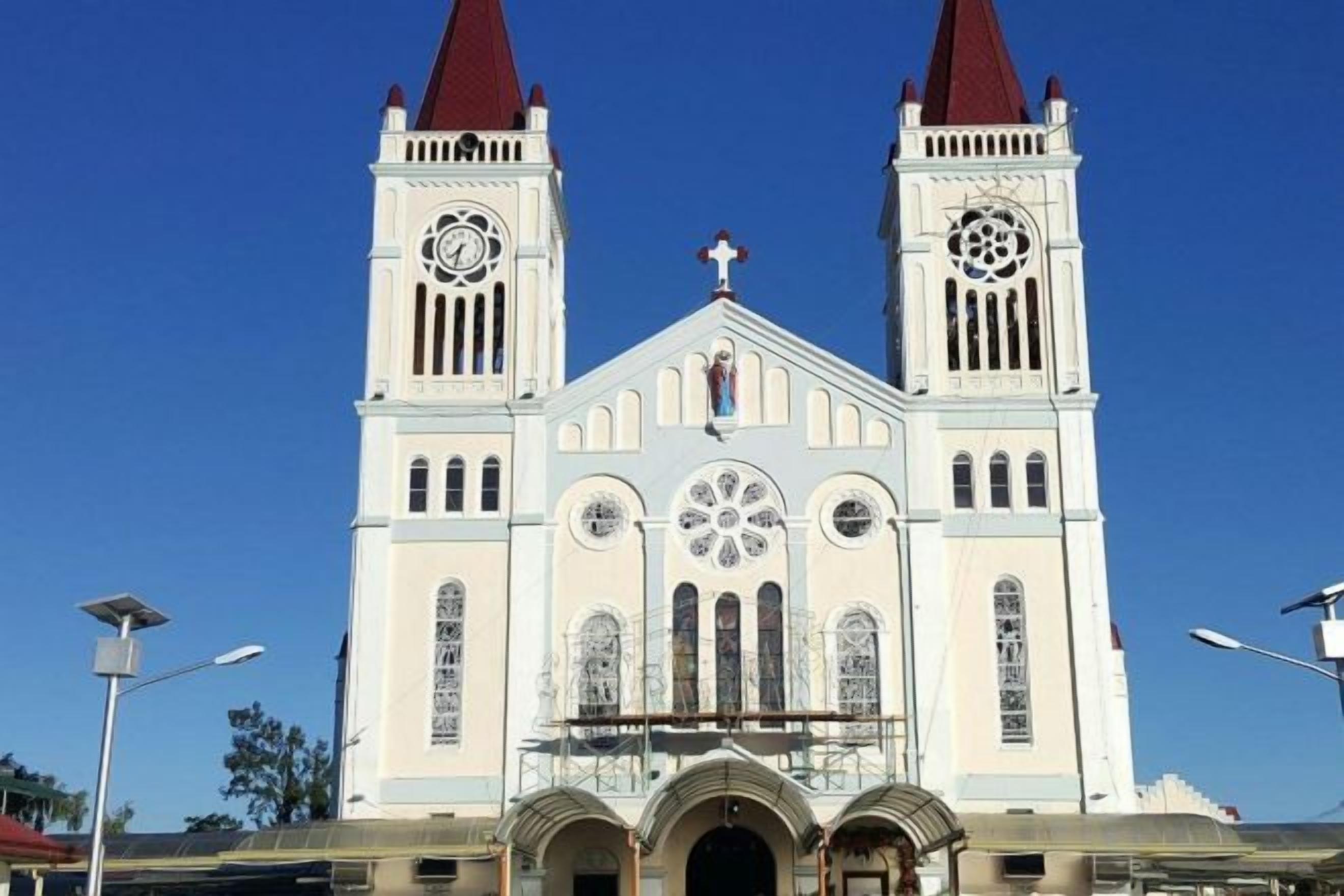 A large church with two towers, a central rose window, and a cross on top.