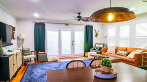 Una sala de estar moderna con una mesa de comedor, sofá y ventilador de techo.