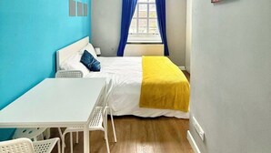 Ein gemütliches Schlafzimmer mit Bett, Schreibtisch und Stuhl.