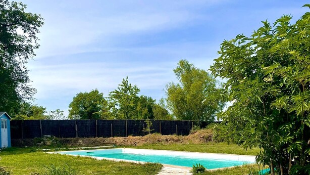 A stone staircase leading to a swimming pool surrounded by greenery and a fence. - Gite "Le Chatel (Prissac)