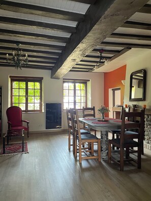 Cozy dining area with a traditional table and chairs, fireplace, and windows.
