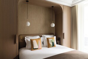 A neatly made bed with two pillows, a wooden headboard, and two pendant lights. - HIGHSTAY - Luxury Serviced Apartments - Bourse (Paris)