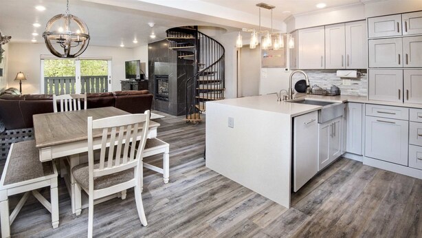 Une cuisine moderne avec des armoires blanches, un îlot central et une cuisinière intégrée.