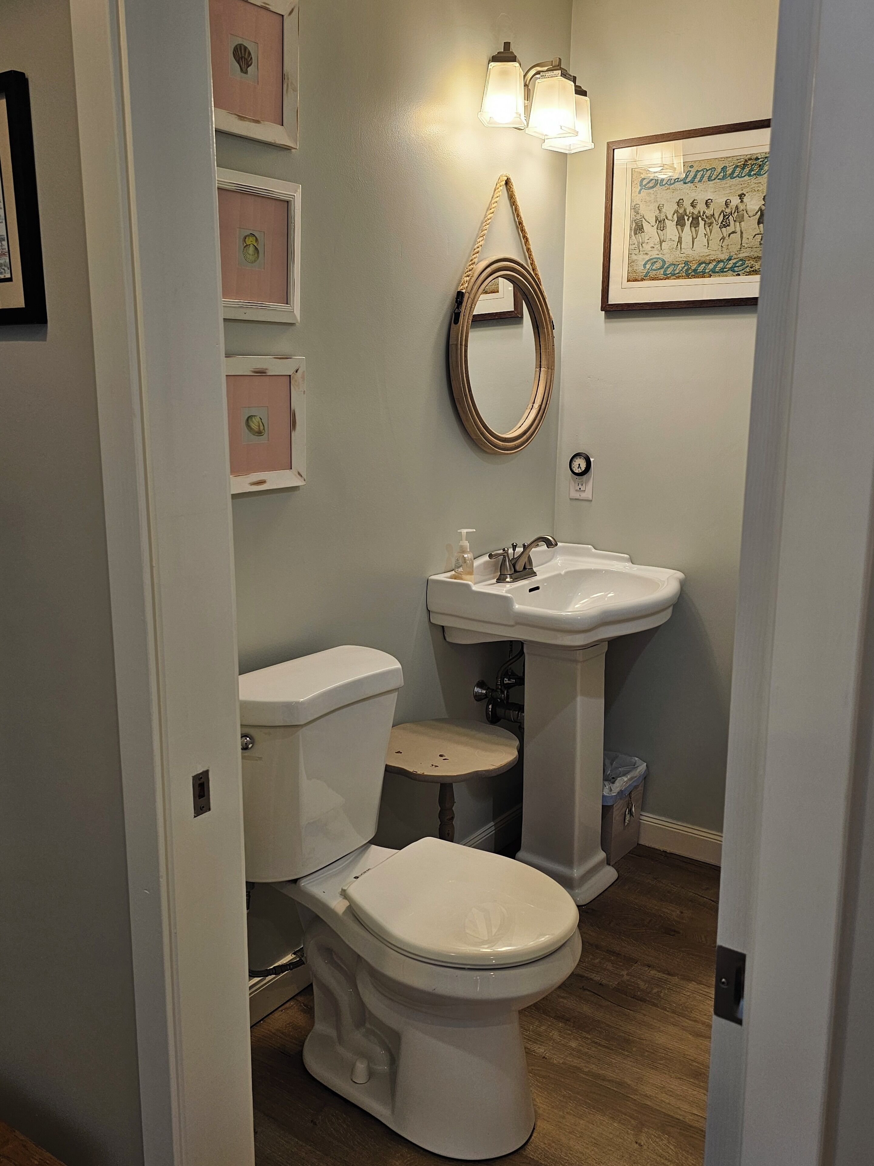 Une salle de bain avec des toilettes, un lavabo et un tableau encadré au mur.