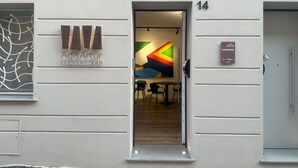 Un bâtiment moderne avec une enseigne indiquant « AdisArtur ELEGANT B&B » et une porte portant le numéro « 14 ».