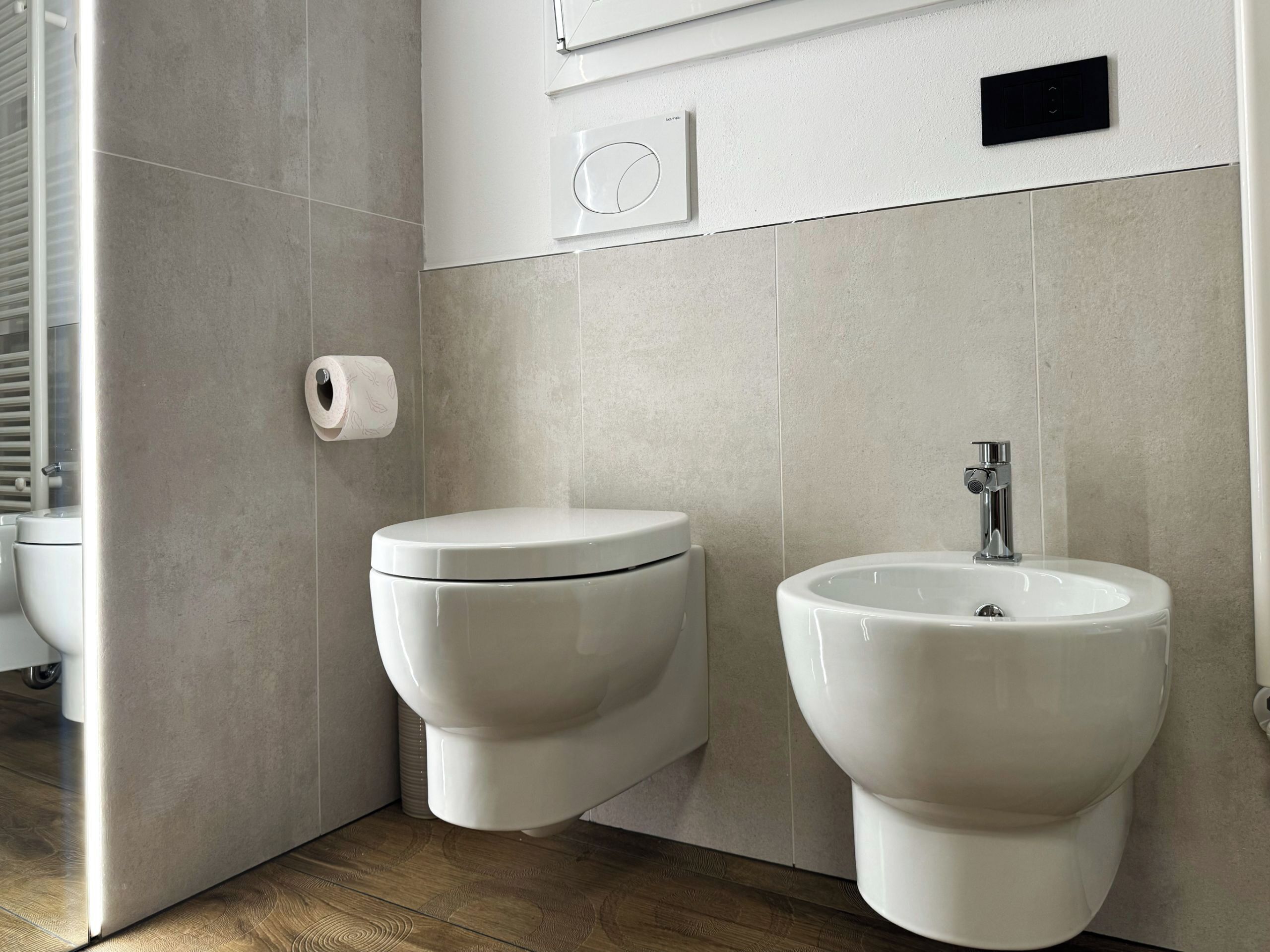 Un baño moderno con inodoro, bidé y lavamanos.