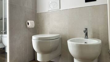 Un baño moderno con inodoro, bidé y lavamanos.