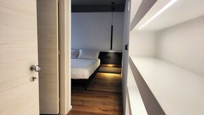 A narrow hallway leading to a bedroom with a bed and a bedside table. - Room 3 Matteo (Orzinuovi)