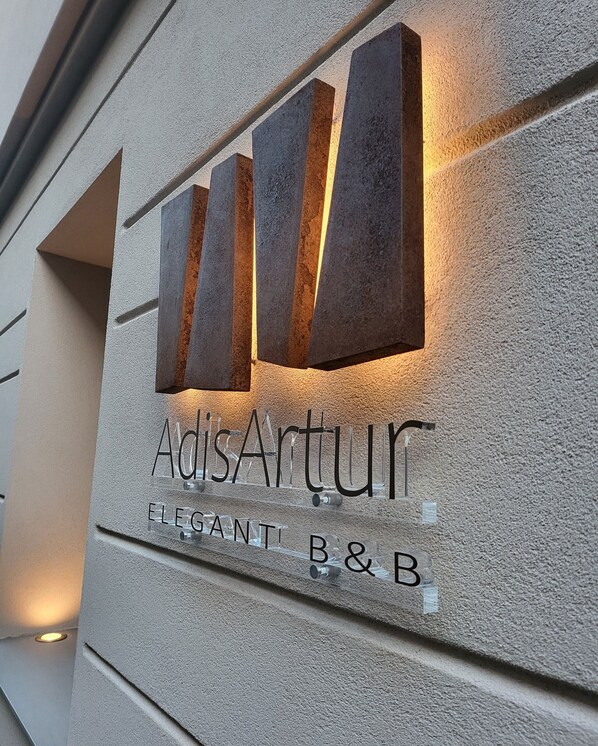 A building facade with a sign that reads 'AdisArtur Eleganti B&B.'
