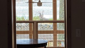Een kamer met een houten plafond, een tafel en uitzicht door een raam.