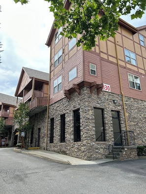 A multi-story building with a stone facade, numbered 330, featuring balconies and large windows. - Luxurious condo next to Golf Course and close to all major attractions.  (Pigeon Forge)