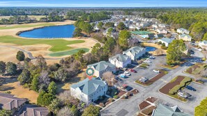 An aerial view of a residential area with houses, a golf course, and a large body of water. - Beach & Golf Vacation 2 (Myrtle Beach)