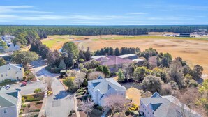 A residential area with houses, a large open field, and a golf course. - Beach & Golf Vacation 2 (Myrtle Beach)