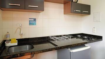 A modern kitchen with dark cabinets, a stainless steel sink, and a gas stove.