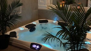 A hot tub with a digital control panel, surrounded by potted plants. - The Factory (Beacon)