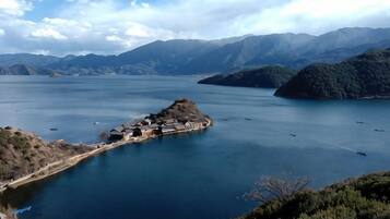 A lake surrounded by mountains with a small island and boats.