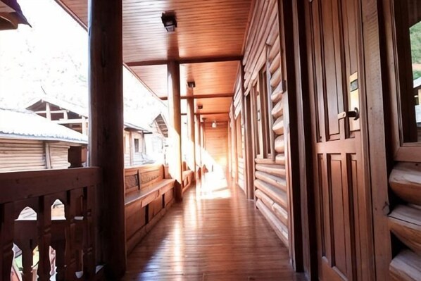 A wooden corridor with a wooden floor, wooden walls, and a wooden door.