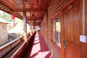 Un couloir en bois avec des bancs et une porte sur la droite.