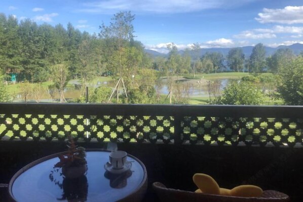 A balcony with a view of a lake, trees, and mountains. - Lugu Lake Zhenmeilige Hostel (Ninglang)
