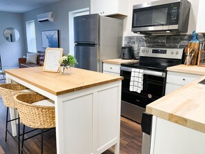 A modern kitchen with a central island, stainless steel appliances, and a wooden countertop. - *Contemporary 1 bed close to Xavier & Downtown* (Cincinnati)