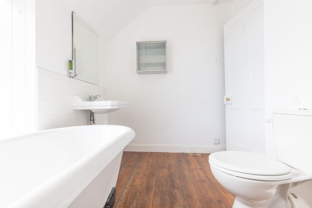A bathroom with a white bathtub, sink, and toilet.