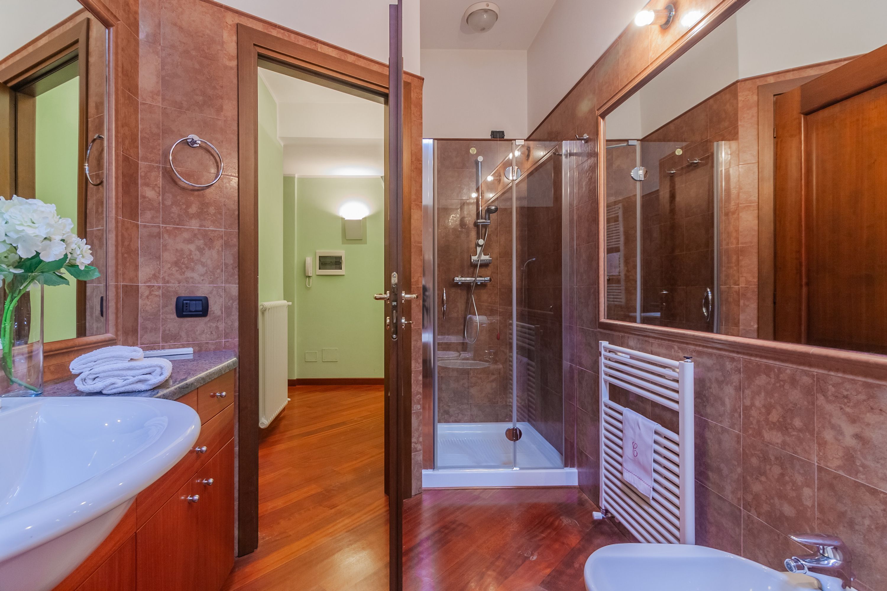 A modern bathroom with a large sink, a glass-enclosed shower, and a walk-in shower.