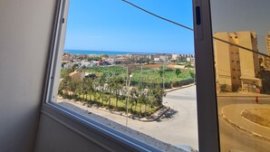 Una ventana con vistas despejadas a una zona residencial, con edificios y una calle.