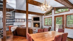 A spacious living area with a fireplace, wooden dining table, and comfortable seating. - 3 Bedroom in the Heart of Vail Village - Bridge Street (Vail)