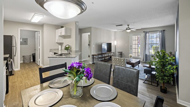 Une cuisine moderne avec un coin repas, un salon et un petit balcon.