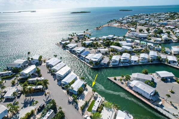 Eine Luftaufnahme eines Küstenresorts mit mehreren bungalowsartigen Unterkünften, einer Marina und freiem Blick auf den Ozean.