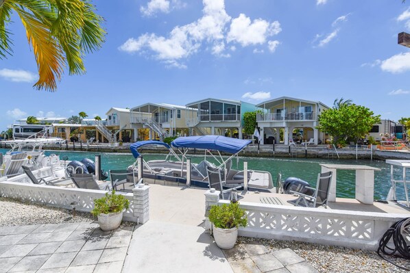 A marina with boats, a waterway, and a row of houses with balconies.