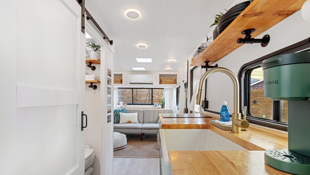A compact kitchenette with a coffee maker, a sink, and a window with a view of the outside.