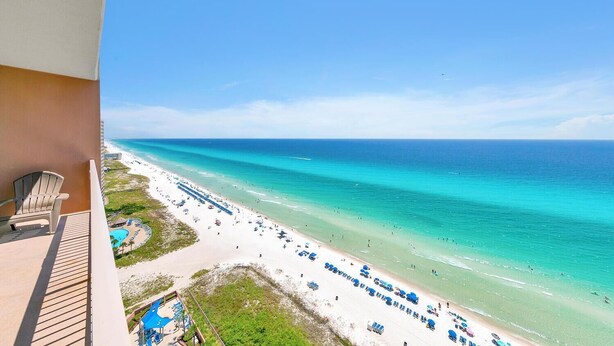 A balcony with a view of a beach, a pool, and a resort area. - Sunrise Beach 2107 (Panama City Beach)