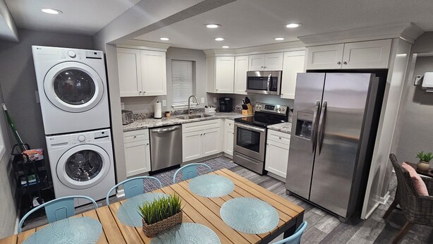 Cocina compacta con lavadora, microondas, cocina y refrigerador.