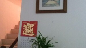 Eine Treppe mit einem gerahmten Bild darüber und einem Kalender mit chinesischen Schriftzeichen an der Wand.