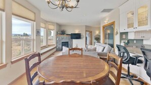 A spacious dining area with a wooden table and chairs, a chandelier, and a view of the outdoors. - Central Oregon Outback Treasure
 (Silver Lake)