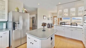A modern kitchen with white cabinetry, stainless steel appliances, and a large island. - Central Oregon Outback Treasure
 (Silver Lake)