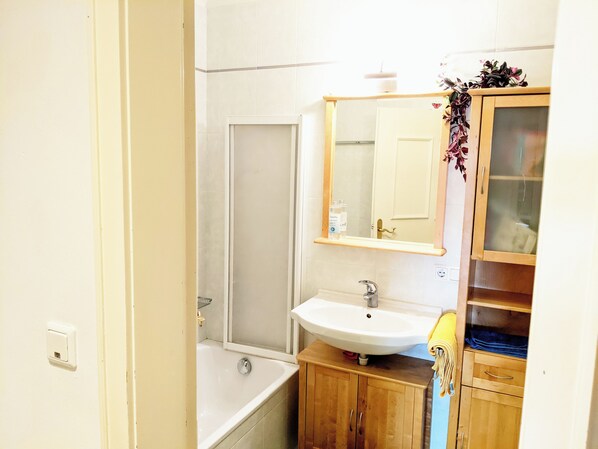 Un baño con bañera, lavabo y espejo.